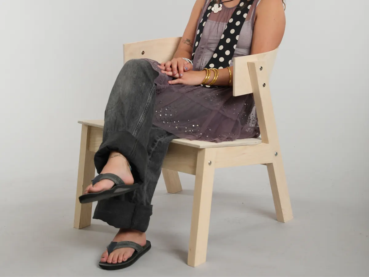 Someone sitting in the plywood chair