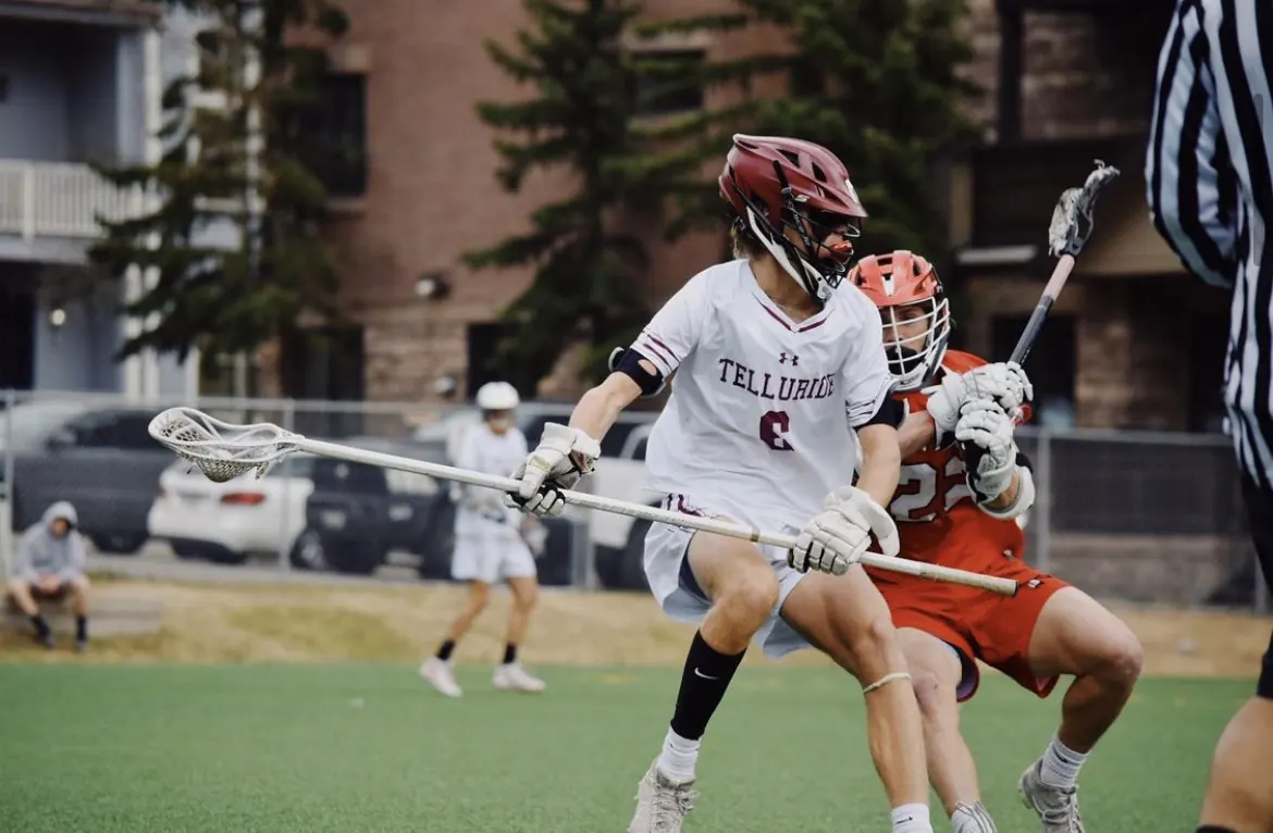 Telluride lacrosse player driving past a defender