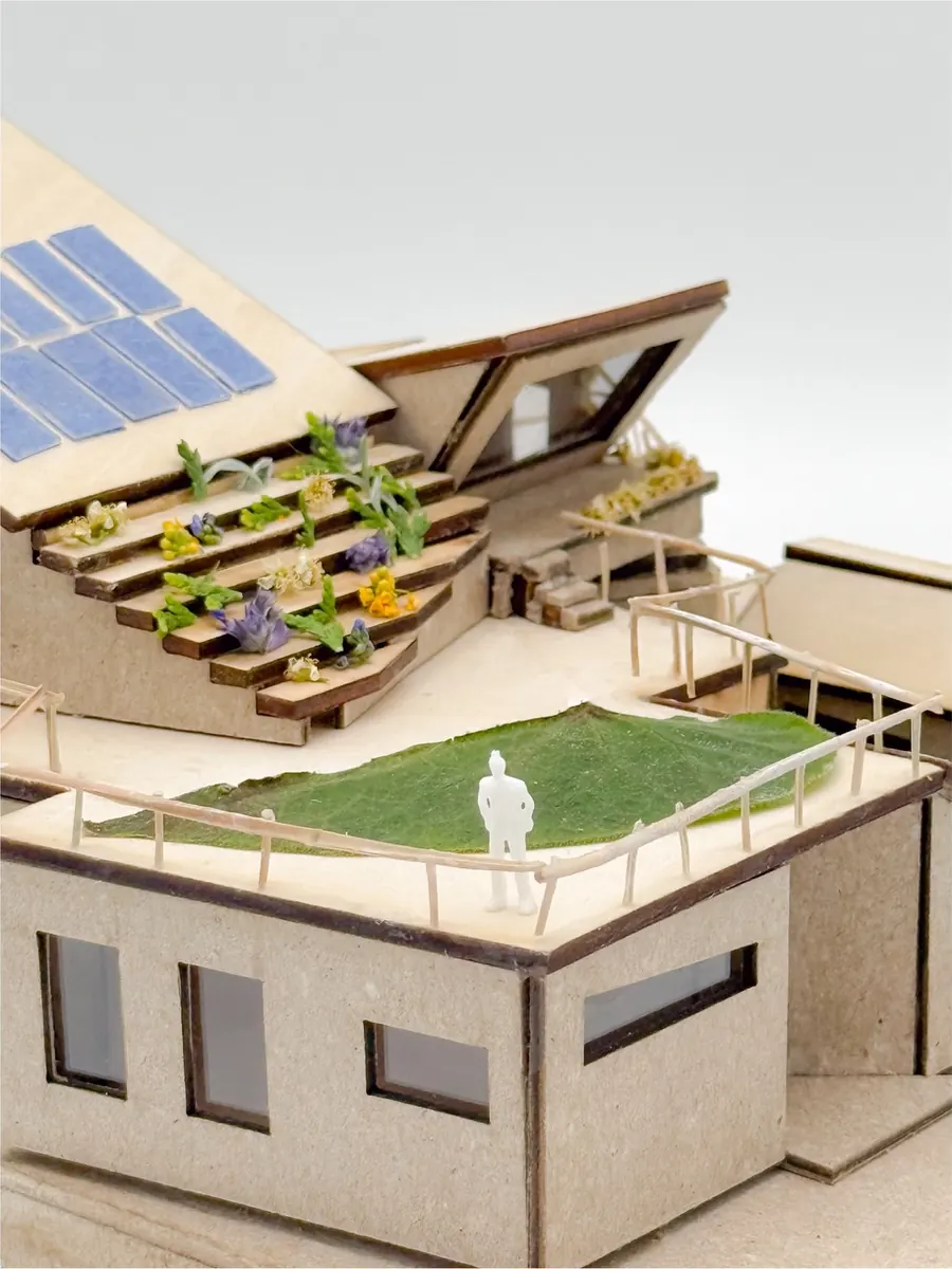 Architectural model with stepped planted terraces, a rooftop lawn and solar panels