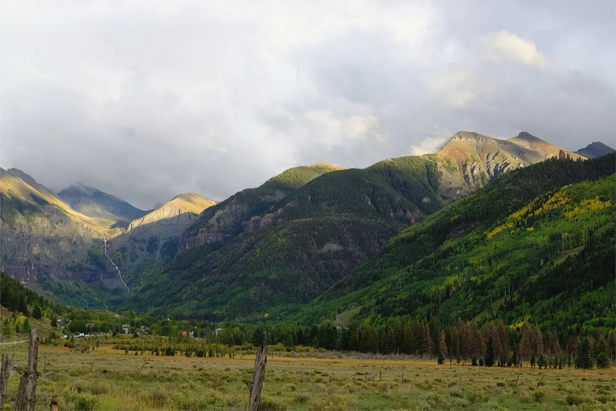 Green mountain valley under low clouds